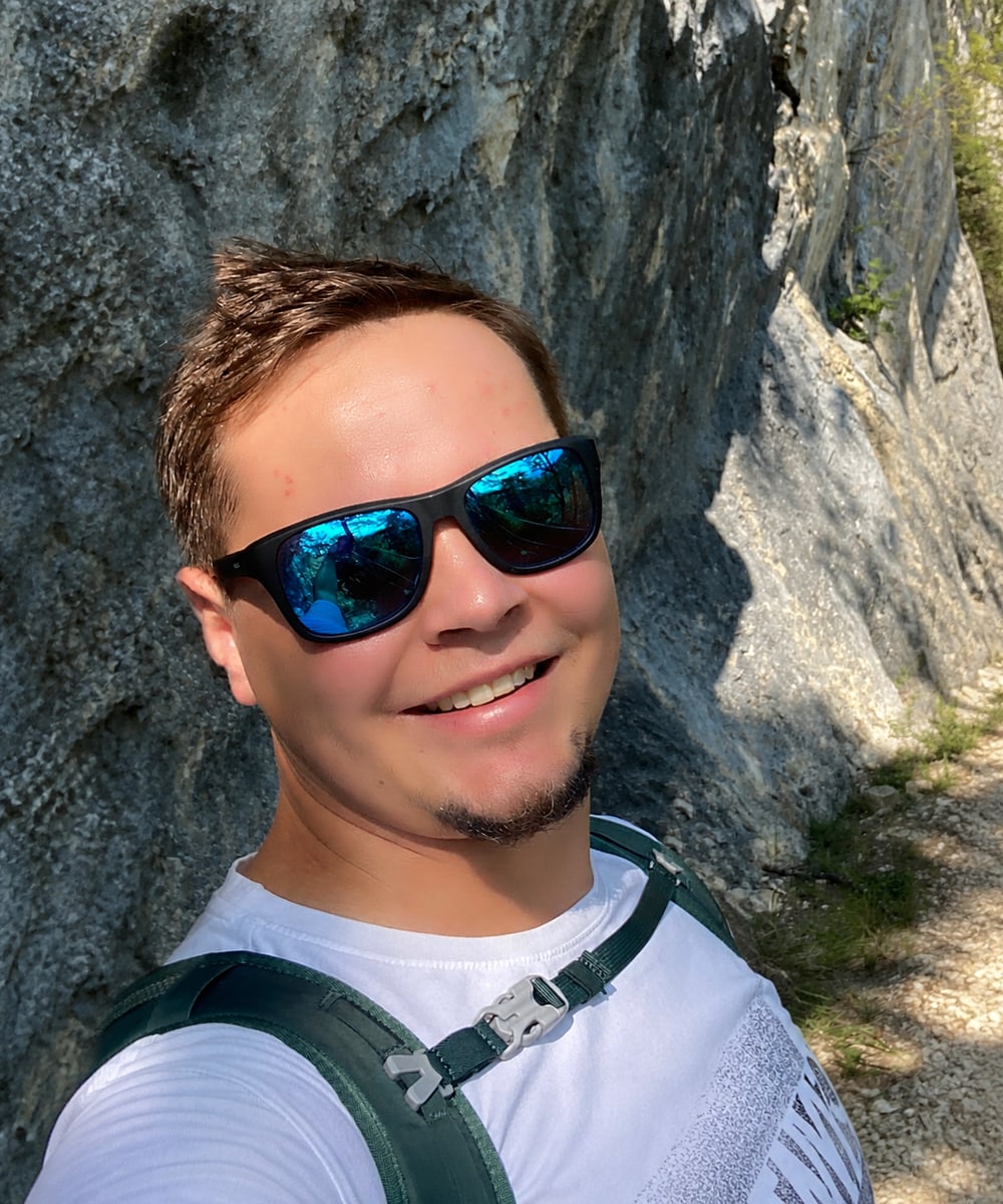Christoph von Alltagsakku bei einer Wanderung vor einer Felswand